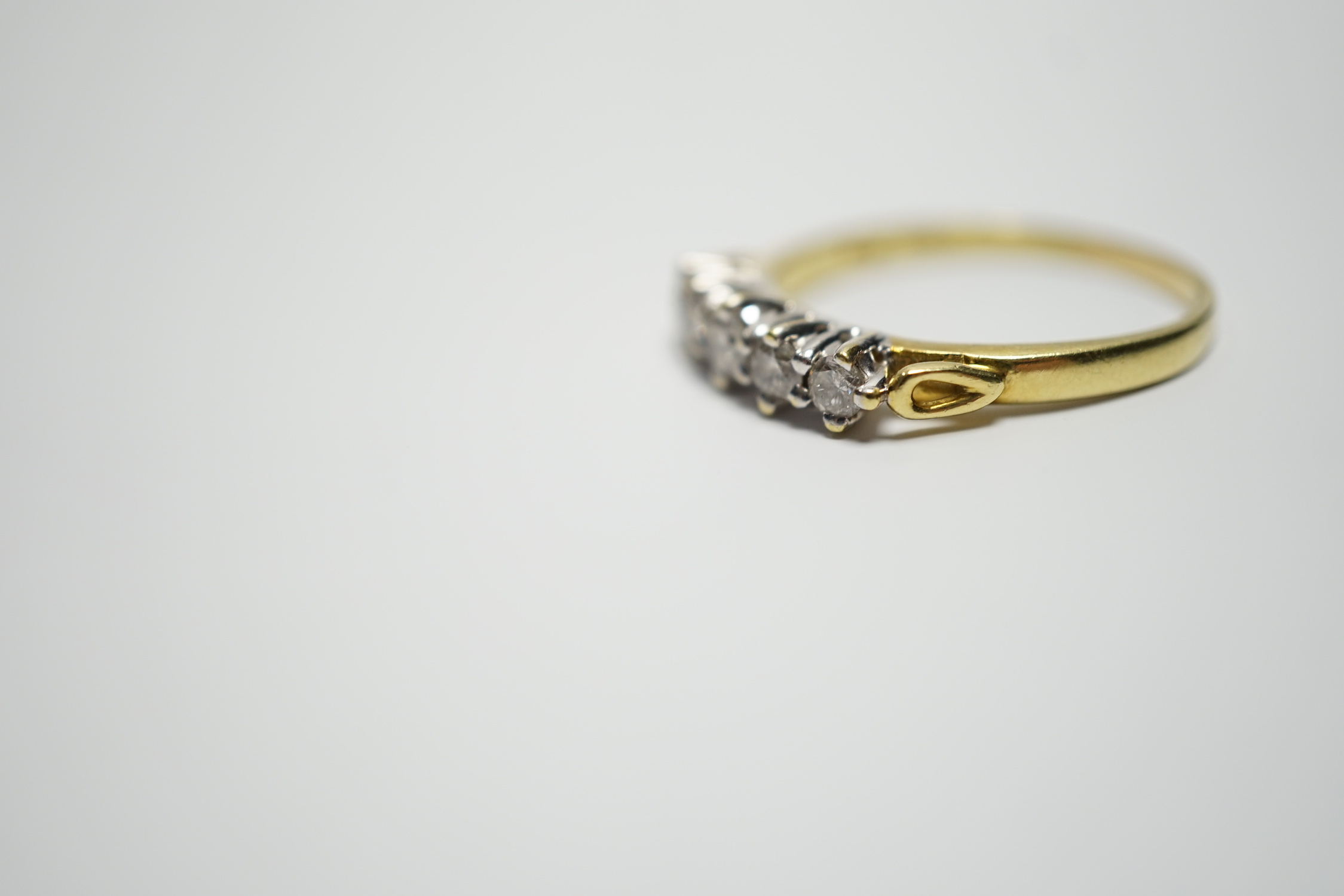 A modern 18ct gold and graduated five stone diamond set half hoop ring, size T, gross weight 4.4 grams.